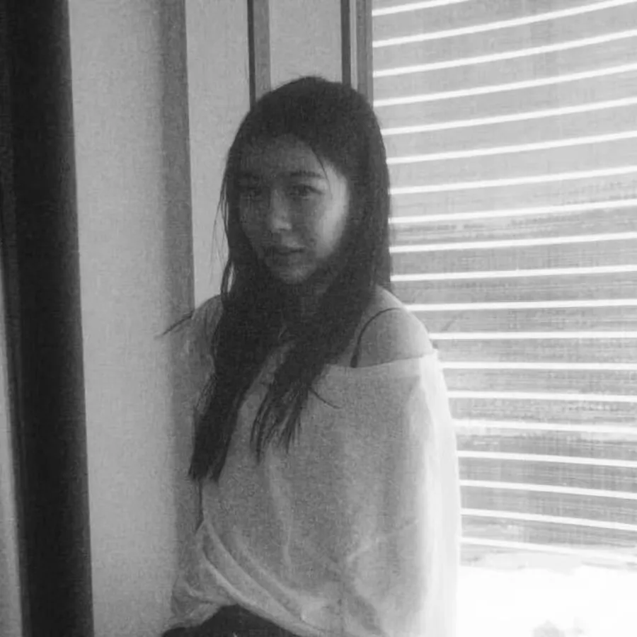 black-and-white portrait by a window